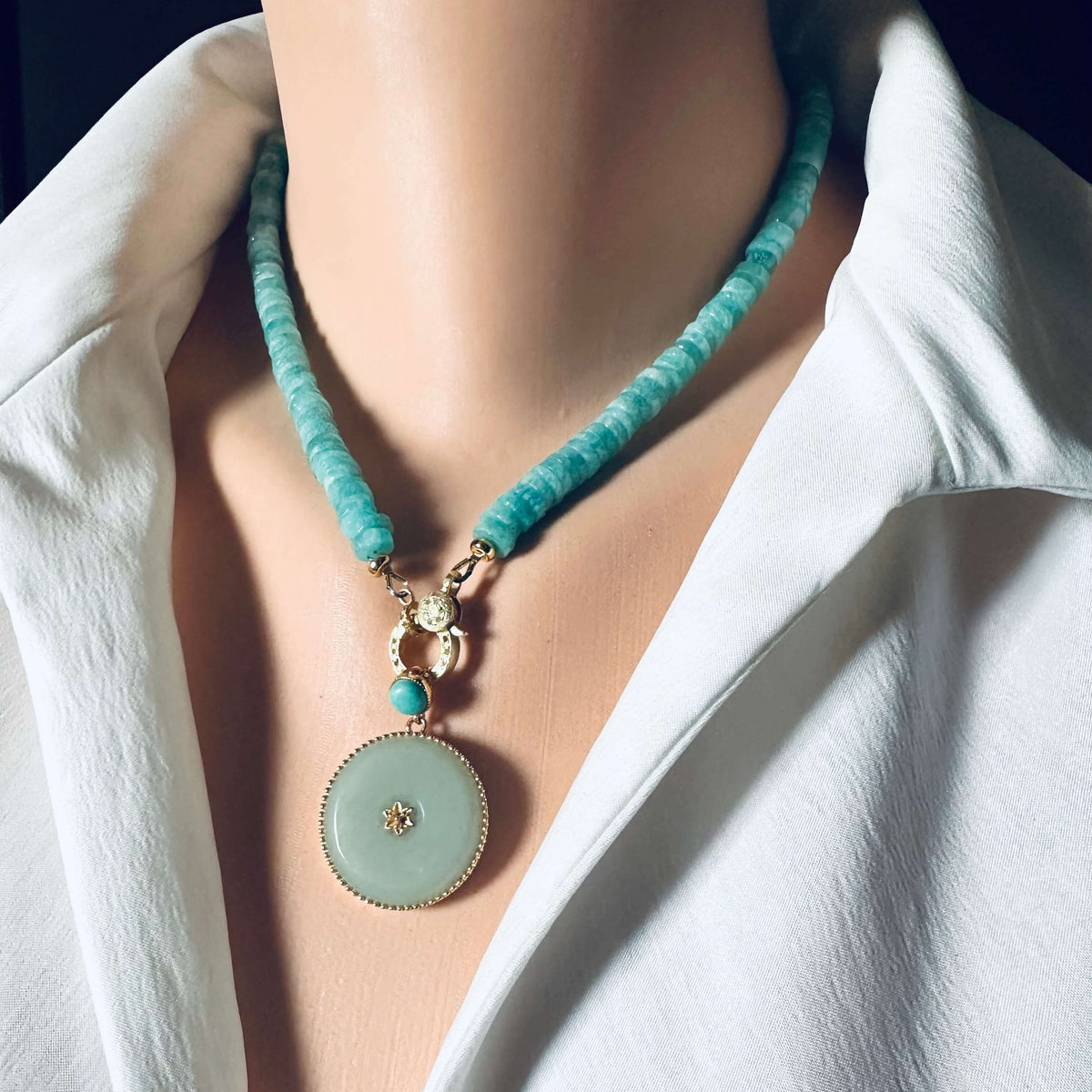 Blue amazonite gemstone necklace with a round pendant, showcasing faceted beads and elegant gold accents.