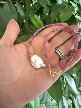 Load image into Gallery viewer, pink tourmaline baroque pearl necklace held in hand against green foliage