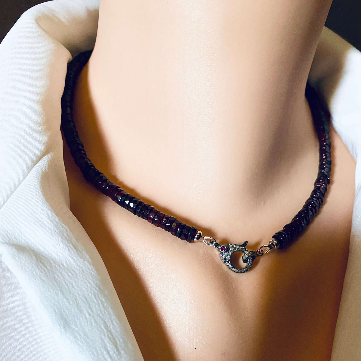 Garnet beaded necklace featuring a diamond and ruby pavé clasp, showcasing rich wine-red tones.