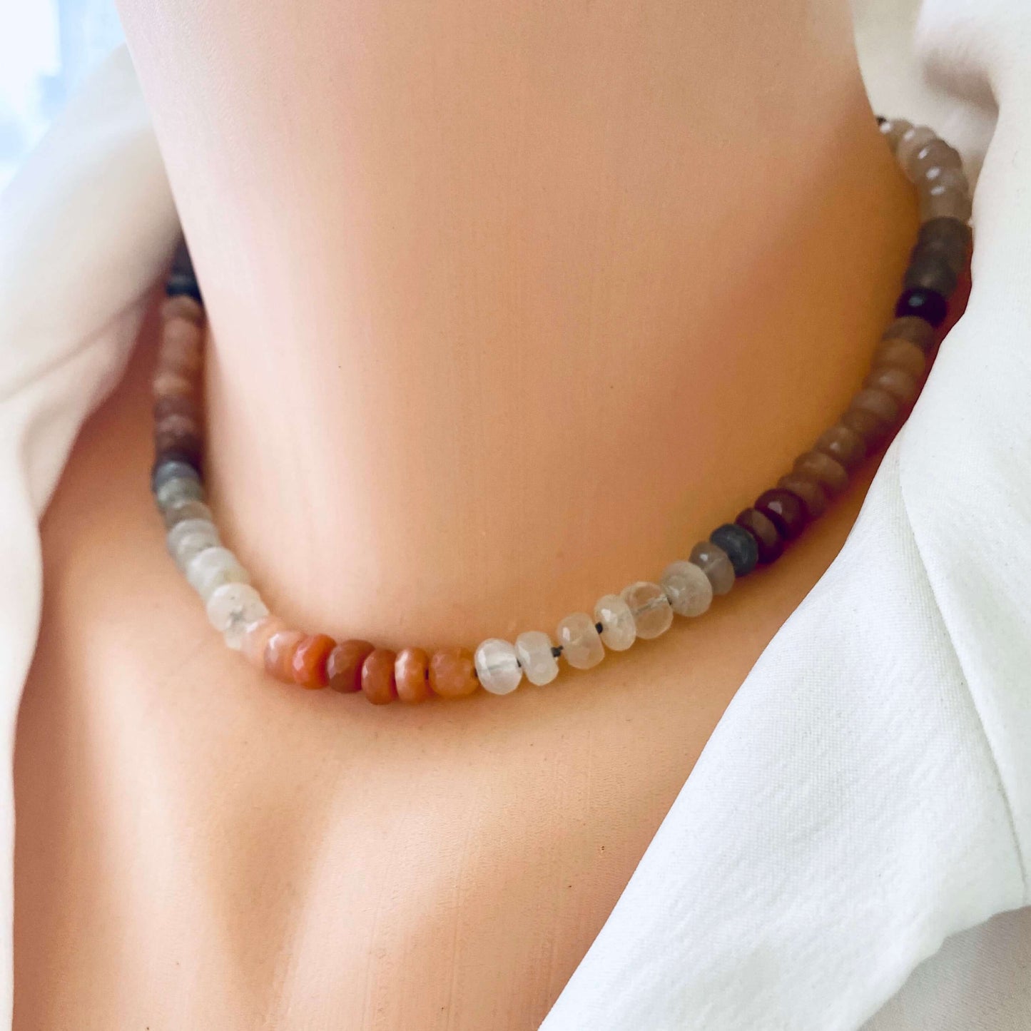 Moonstone candy necklace with sunstone beads, showcasing a luminous and elegant design on a mannequin's neck.