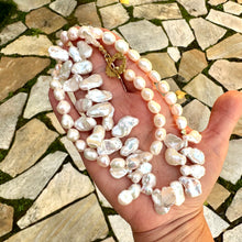 Load image into Gallery viewer, Add a touch of organic elegance to your look with this stunning 25" white Keshi pearls necklace, featuring a unique asymmetrical design that showcases both petal-shaped and nugget pearls.
At the side, a beautiful golden palm leaf toggle clasp adds a tropical flair