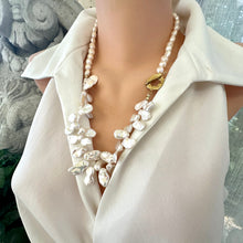 Load image into Gallery viewer, Add a touch of organic elegance to your look with this stunning 25" white Keshi pearls necklace, featuring a unique asymmetrical design that showcases both petal-shaped and nugget pearls.
At the side, a beautiful golden palm leaf toggle clasp adds a tropical flair