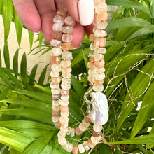 Load image into Gallery viewer, Hand-knotted necklace with mixed moonstone and a baroque pearl at the center, threaded with orange string, 20 inches long, featuring a sterling silver marine clasp.