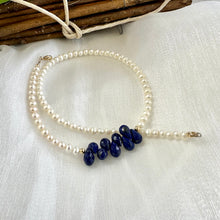 Load image into Gallery viewer, double wrap bracelet, featuring two strands of shimmering freshwater pearls beautifully accented with deep blue Lapis Lazuli teardrop briolettes, Gold filled details.