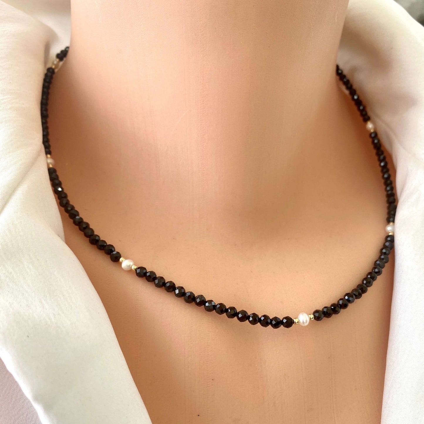 Black spinel pearl choker necklace worn on mannequin, front view