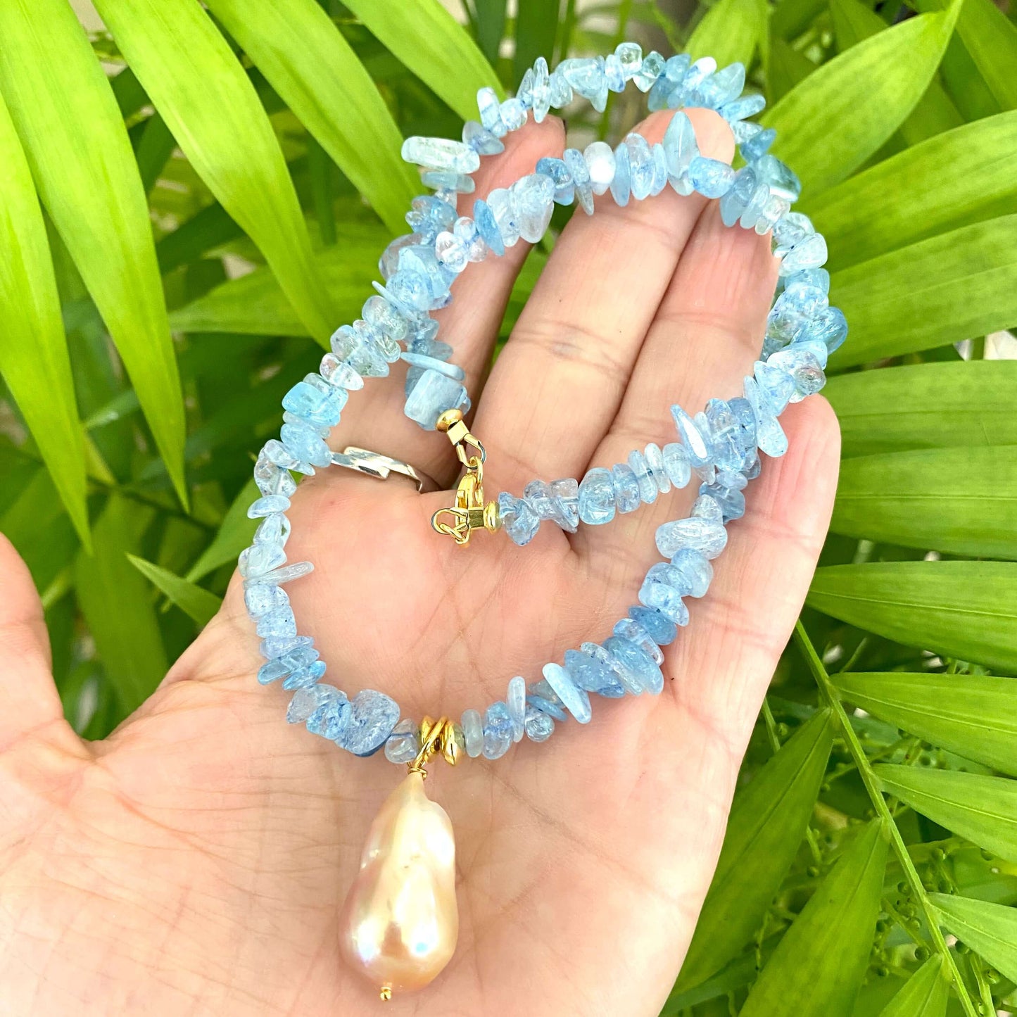 Aquamarine baroque pearl necklace featuring blue Aquamarine beads with a golden pink Baroque pearl pendant.