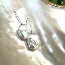 Carica l'immagine nel visualizzatore di Gallery, White freshwater pearl drop earrings rhodium-plated silver close-up on white pearl shell, rectangular design handmade in Canada.