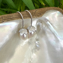 Carica l'immagine nel visualizzatore di Gallery, Rice Pearl Earrings – silver design displayed on pearl shell with green leaves