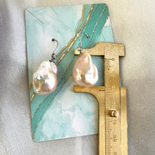 Load image into Gallery viewer, Golden Baroque Pearl Earrings – measured for size against turquoise backdrop with ruler