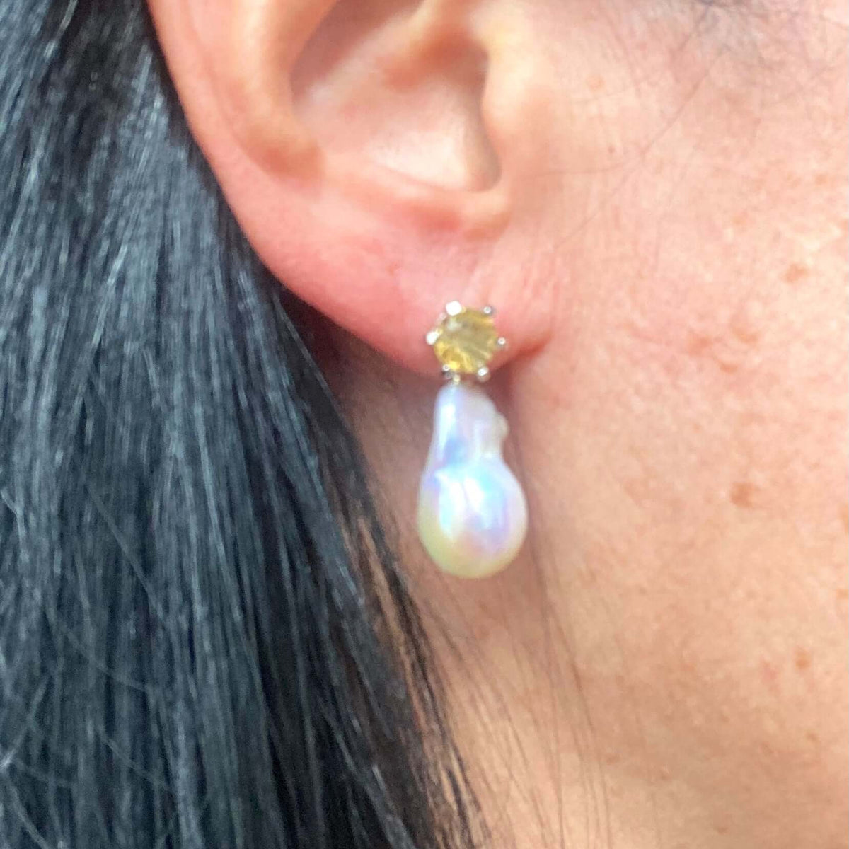 Side view of woman wearing citrine stud earrings with removable pearl drops