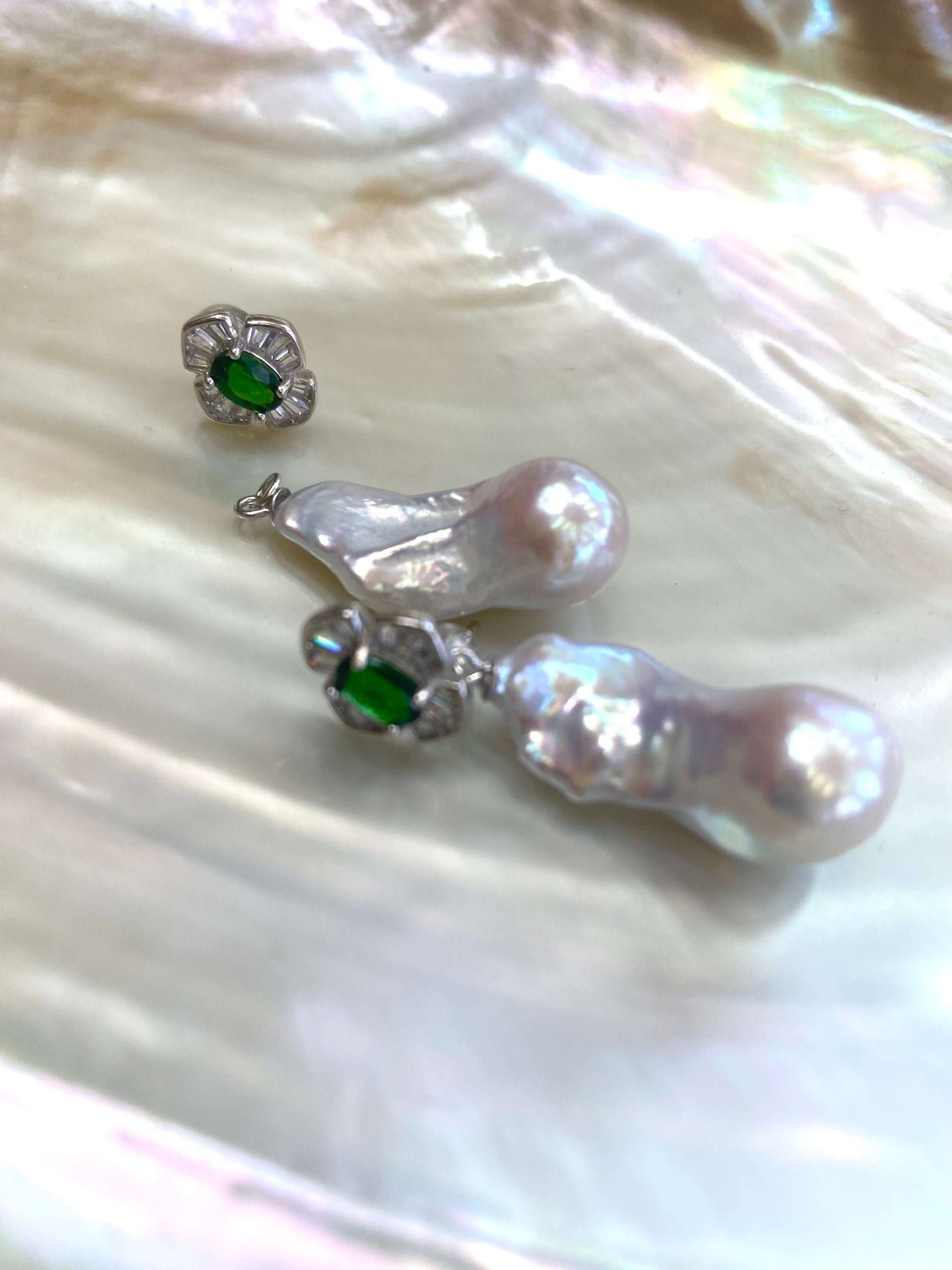 Close-up of green diopside baroque pearl drop earrings on white pearl shell background — elegant gemstone jewelry by Loulia Pearl Jewelry