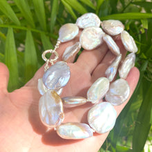 Load image into Gallery viewer, Close view of large coin pearl necklace with natural pearls on leaf backdrop