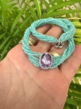 Lade das Bild in den Galerie-Viewer, Amethyst Amazonite Choker Necklace – 8-Strand Twisted Gemstone Collar displayed on a hand with green foliage.