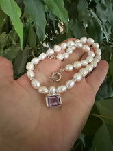 Lade das Bild in den Galerie-Viewer, White Nugget Pearl Necklace with Amethyst Pendant – 'Viola' Collection held in hand, showcasing elegance and natural beauty.