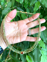Lade das Bild in den Galerie-Viewer, Green orange garnet necklace displayed in hand, showcasing multi-strand gold vermeil design and color details.