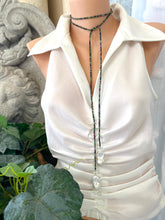 Load image into Gallery viewer, Ruby Zoisite Baroque Pearl Necklace displayed on a mannequin in a stylish lariat design with greenery in the background.
