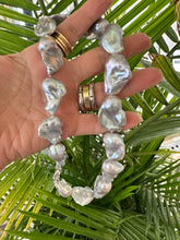 Load image into Gallery viewer, Handmade baroque pearl necklace with silver details, showcasing large silver-grey pearls and natural iridescence.