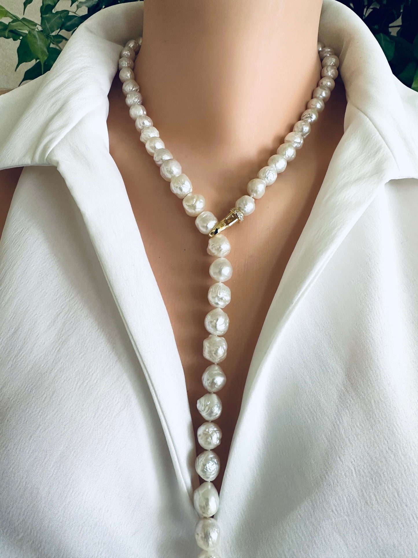 Edison pearl Y necklace featuring baroque pearls displayed elegantly along the neckline of a white shirt.