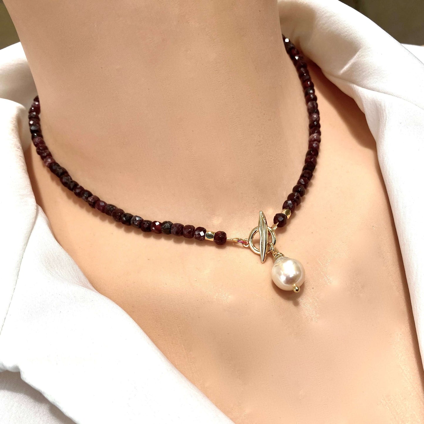 Garnet toggle necklace with baroque pearl charm, showcasing deep red garnet beads and elegant craftsmanship.