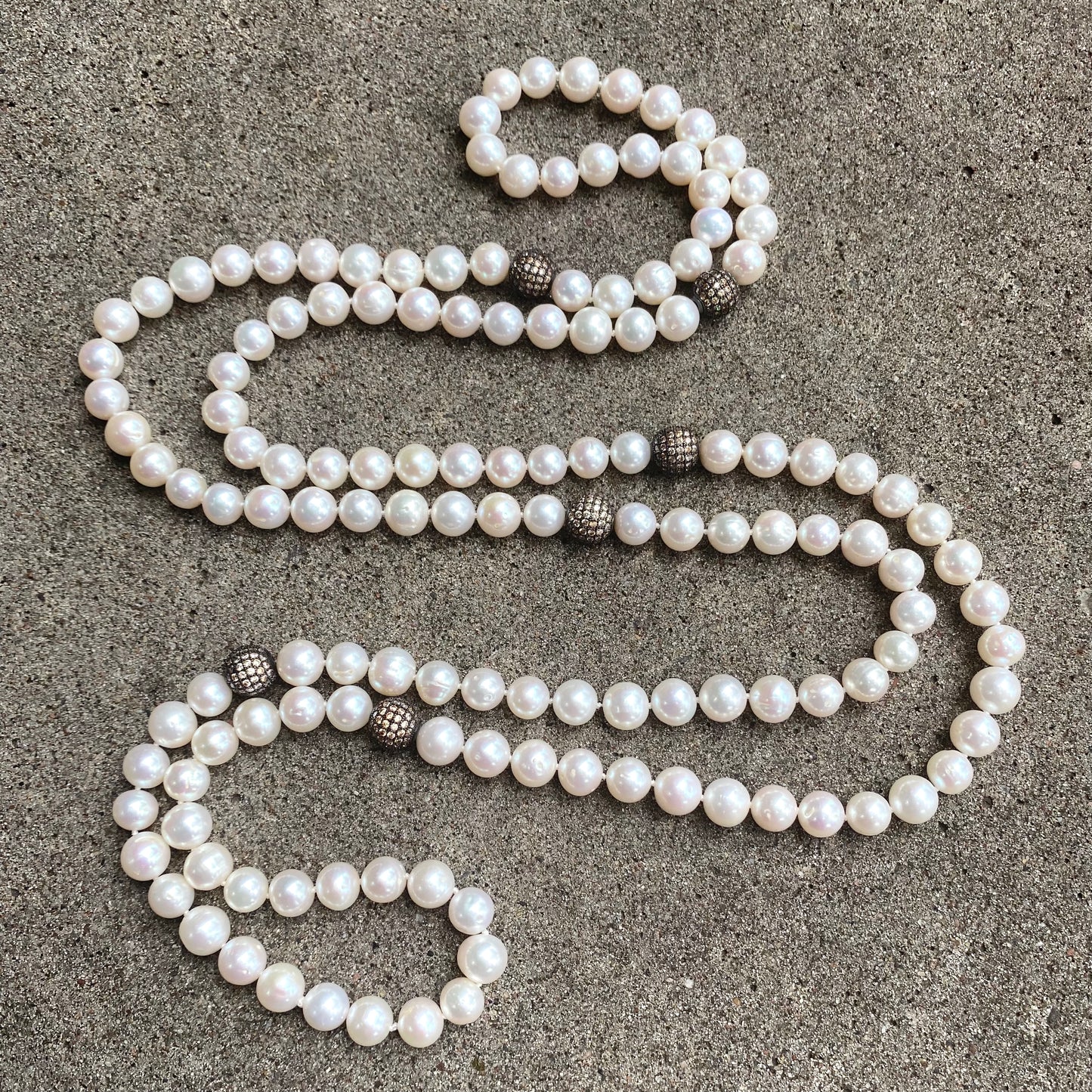 Elegant 55 inch freshwater pearl necklace with CZ pave silver beads on dark grey background, handmade in Canada.