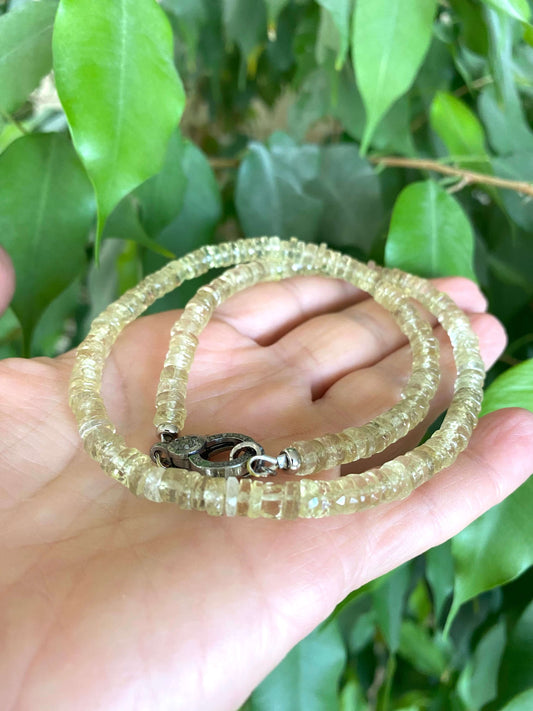 Lemon quartz beaded necklace with oxidized silver pavé clasp held in hand, showcasing faceted beads and shimmering elegance.