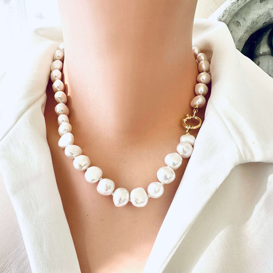 Small baroque pearl classic necklace worn on model, showcasing the elegant pearls and golden clasp.