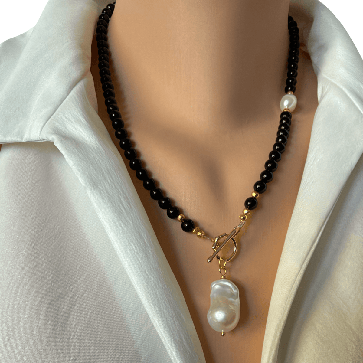 The pearl Solitaire Toggle necklace, back onyx and gold coated pyrite beads, finished with a gold plated toggle clasp and a beautiful white baroque pearl pendant 19-20 inches