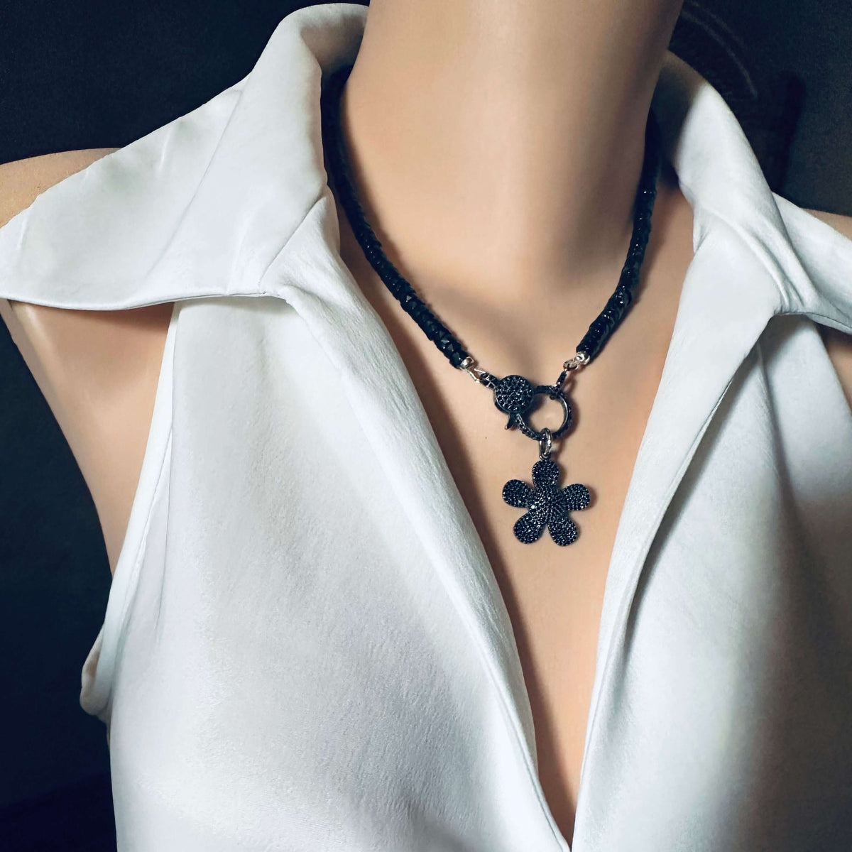Black Spinel Daisy Pendant Necklace in Oxidized Silver – 18” worn on a mannequin with a white blouse.