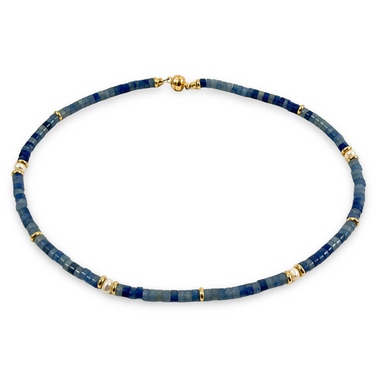 A beaded necklace featuring dark blue lapis lazuli stones separated by small gold spacer beads, with a gold clasp, shown on a plain white background.