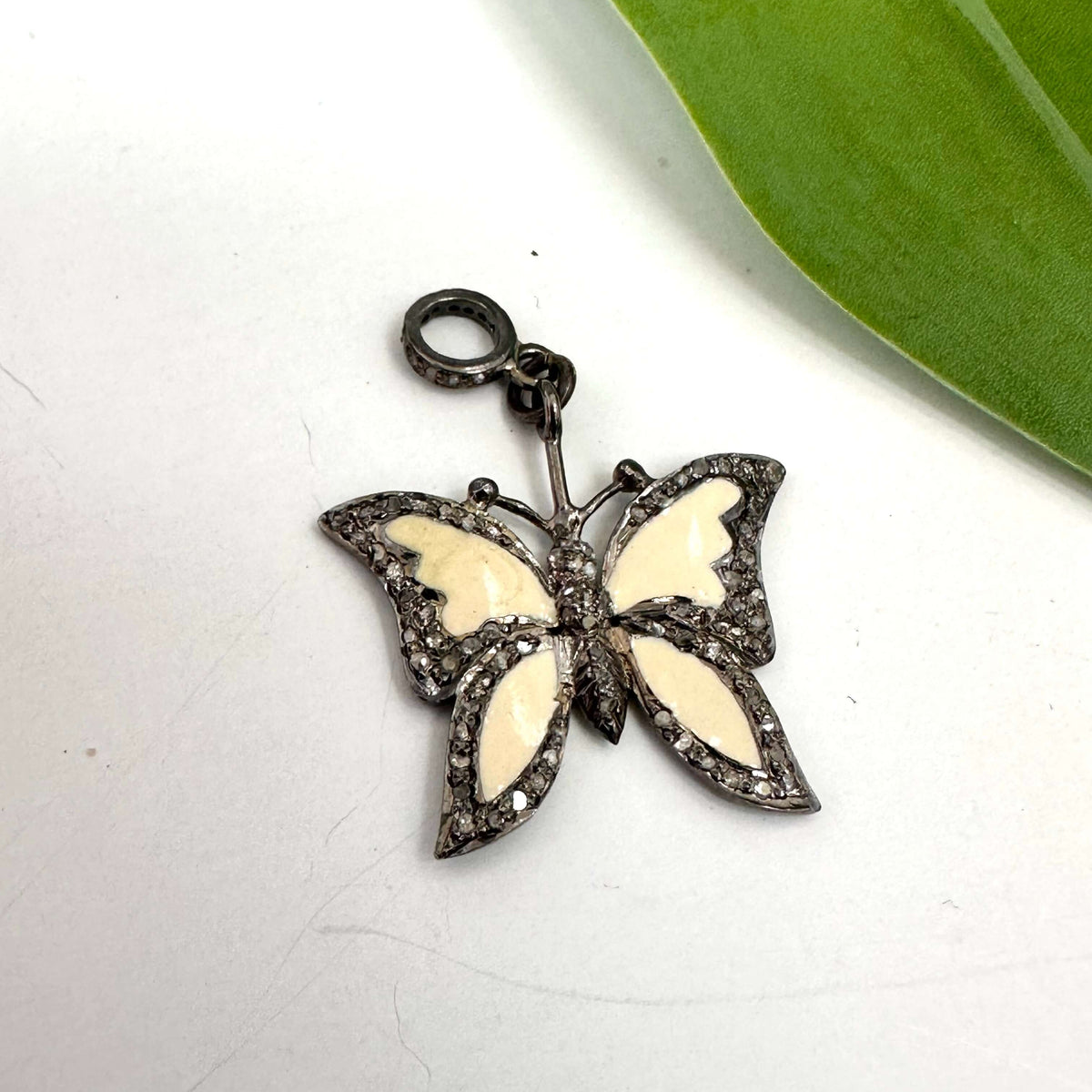 Enamel butterfly pendant with diamond pavé in sterling silver showcasing off-white enamel wings and sparkling accents.