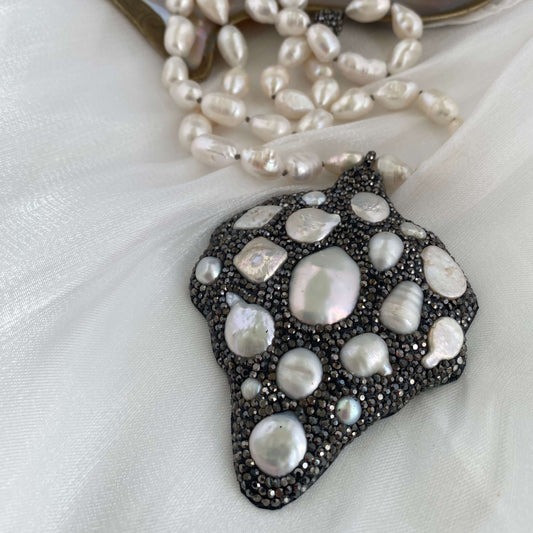 Long white pearl nugget necklace with Pavé pendant on a soft background, highlighting the luminous freshwater pearls.