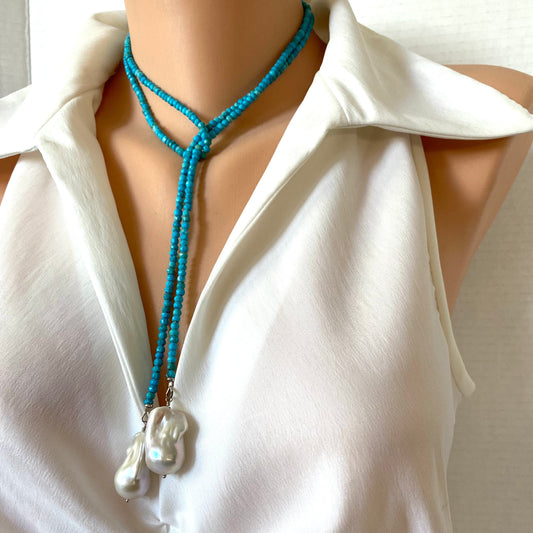 A turquoise beaded lariat-style necklace with two baroque pearls at the end, displayed on a mannequin wearing a white sleeveless blouse.