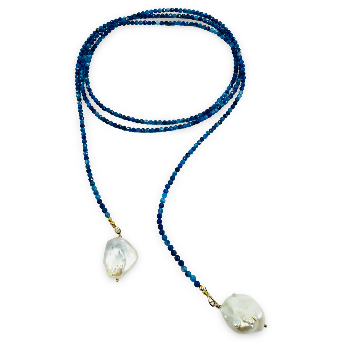A beaded necklace featuring dark blue faceted beads and two large, irregular white mother-of-pearl drop pendants, displayed on a clean white background.
