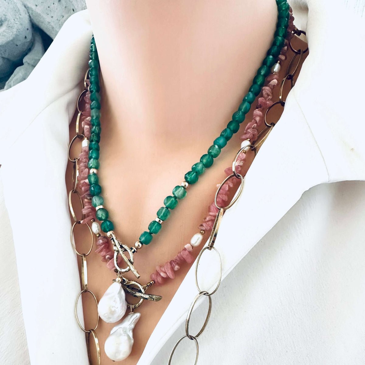 Rhodochrosite pearl toggle necklace layered with other necklaces showing versatility of toggle design