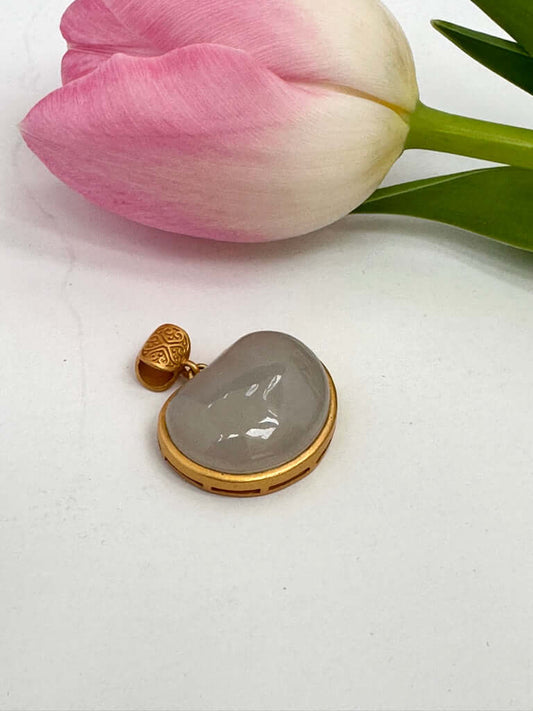 Hotan jade charm pendant in gold bezel featuring natural nephrite jade with a smooth teardrop shape and pink tulip.