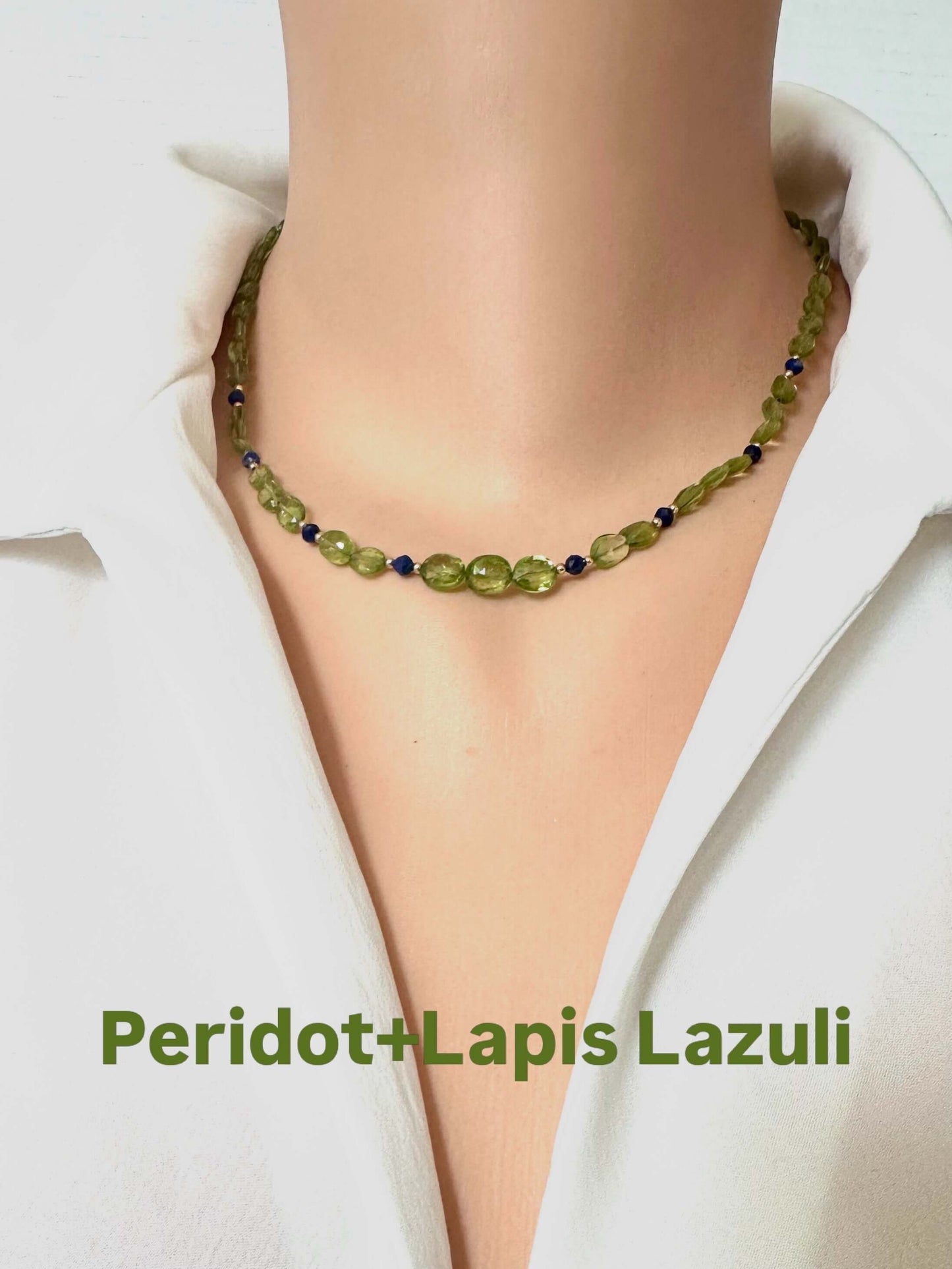 A beaded necklace made of olive-green peridot and blue lapis lazuli stones, shown on a mannequin torso wearing a white shirt. The text 'Peridot+Lapis Lazuli' is written at the bottom.