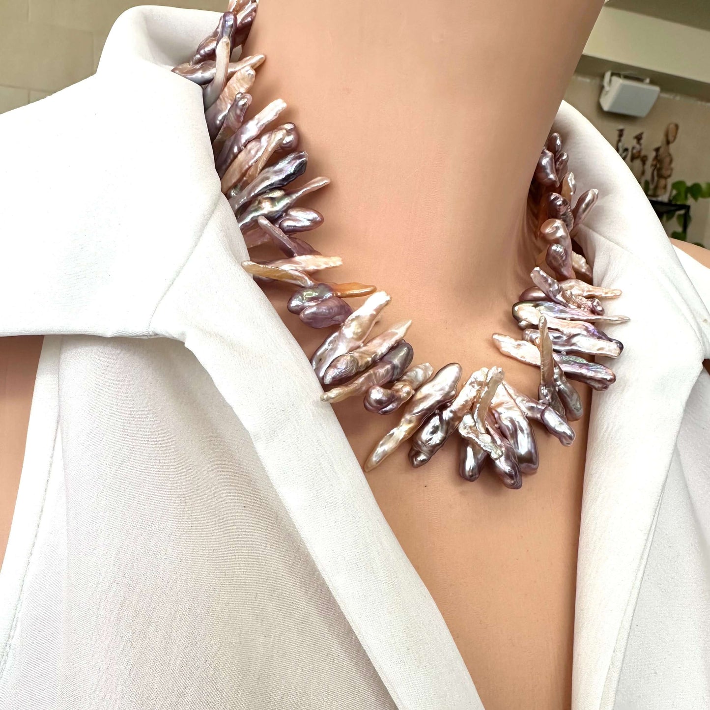 Biwa Pearl Necklace displaying lustrous multicolor stick pearls worn by mannequin side angle.