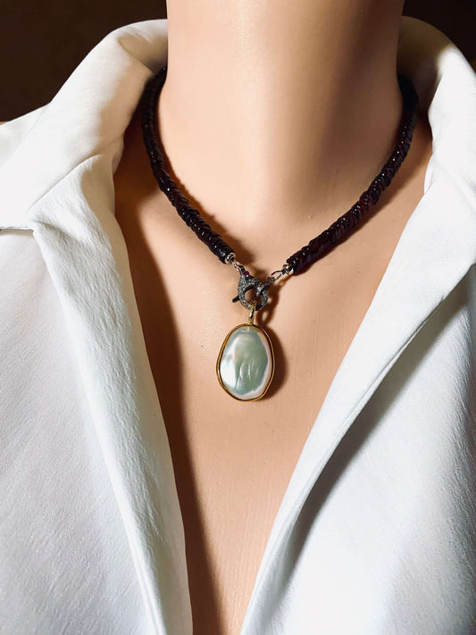 Baroque pearl pendant in gold vermeil with double-sided pearl charm worn on a model's neck.