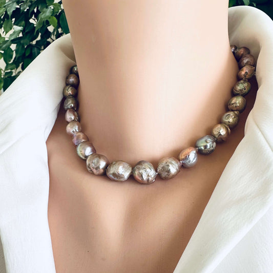 Edison pearl necklace with magnetic clasp worn at neckline showing metallic pink green lustre