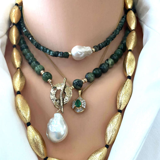 Seraphinite pearl choker necklace layered with pearl and gold necklaces featuring baroque pearl centerpiece