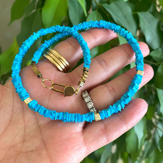 Turquoise choker necklace with natural turquoise beads in hand, showcasing vibrant color and modern elegance.