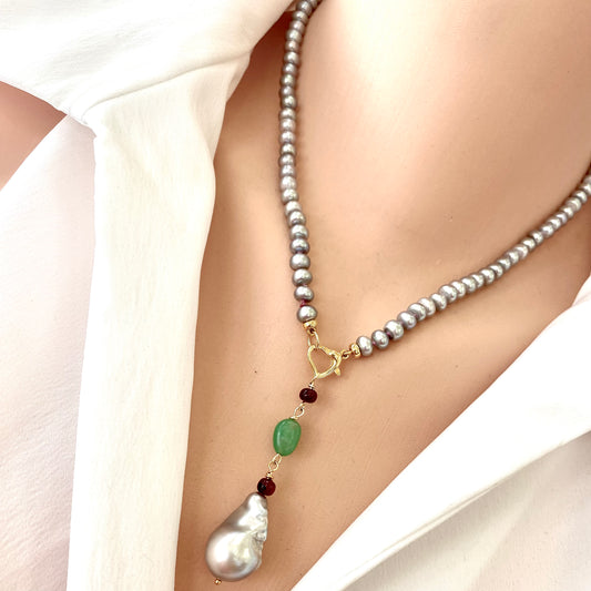 Grey pearl necklace with ruby and chrysoprase pendant displayed elegantly on a model's neck.