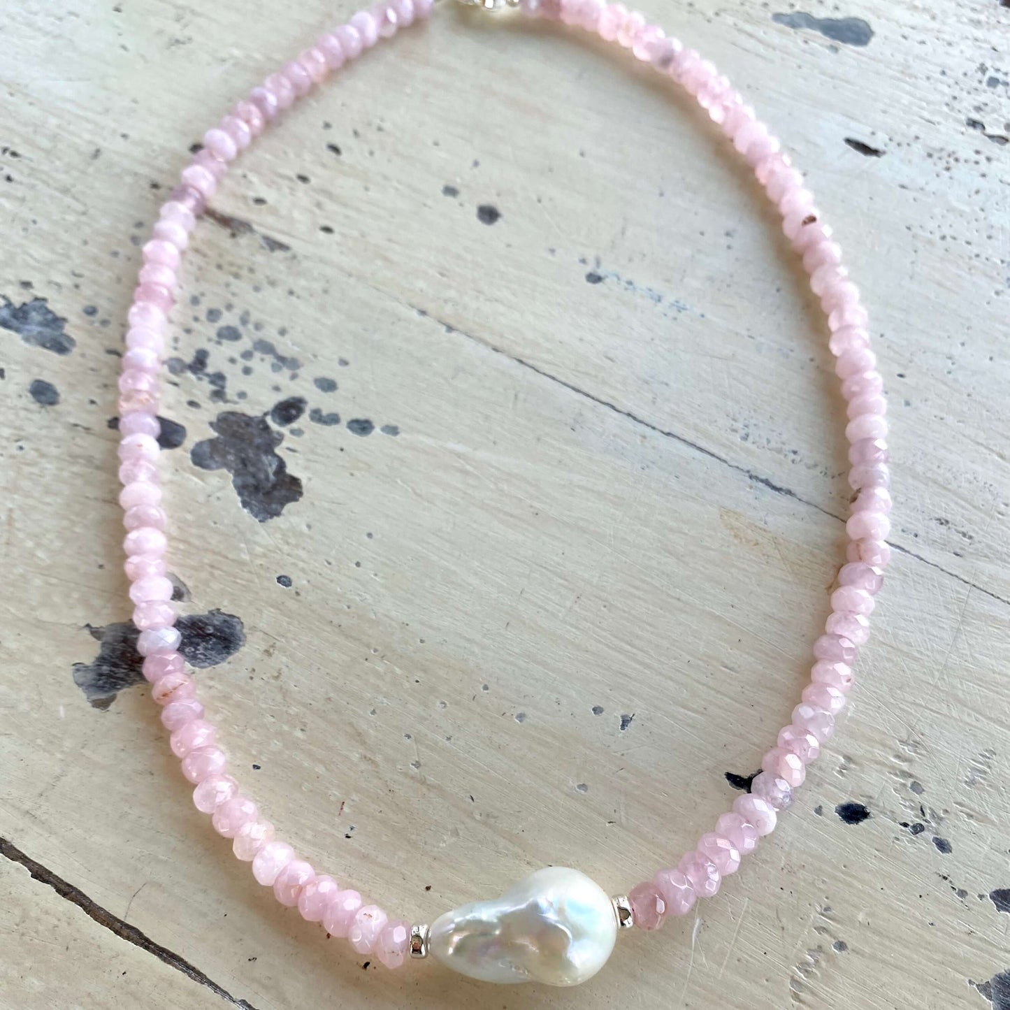 Rose quartz pearl necklace laid out to show full length and baroque pearl focal point, handmade in Canada