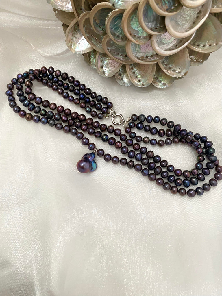 Black pearl necklace with a heart-shaped pendant on a white background