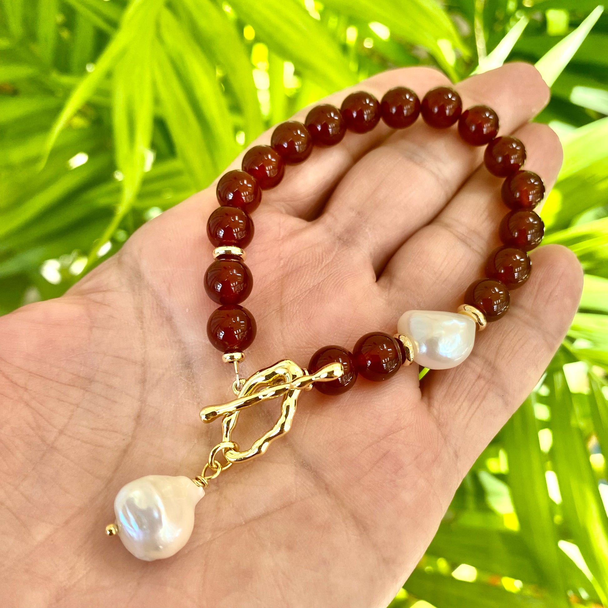 Carnelian pearl bracelet featuring burnt orange carnelian beads and white baroque pearls, showcasing earthy elegance.