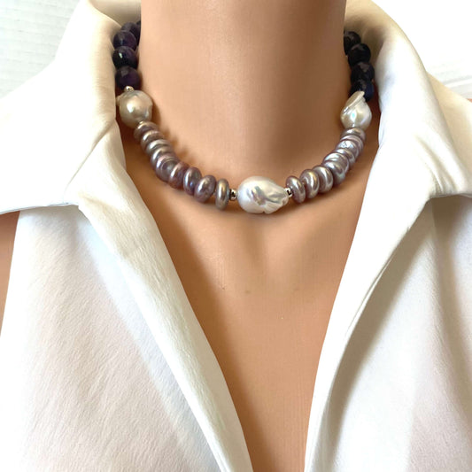 A close-up of a double-strand pearl necklace worn on a mannequin torso wearing a white satin shirt. The necklace features a top strand of dark purple beads and a bottom strand of silver-gray and white baroque pearls.