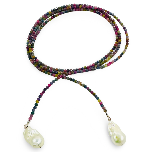 A multi-strand beaded necklace with small faceted beads in mixed earthy and jewel tones, featuring two large white baroque pearls at the ends, displayed on a clean white background.