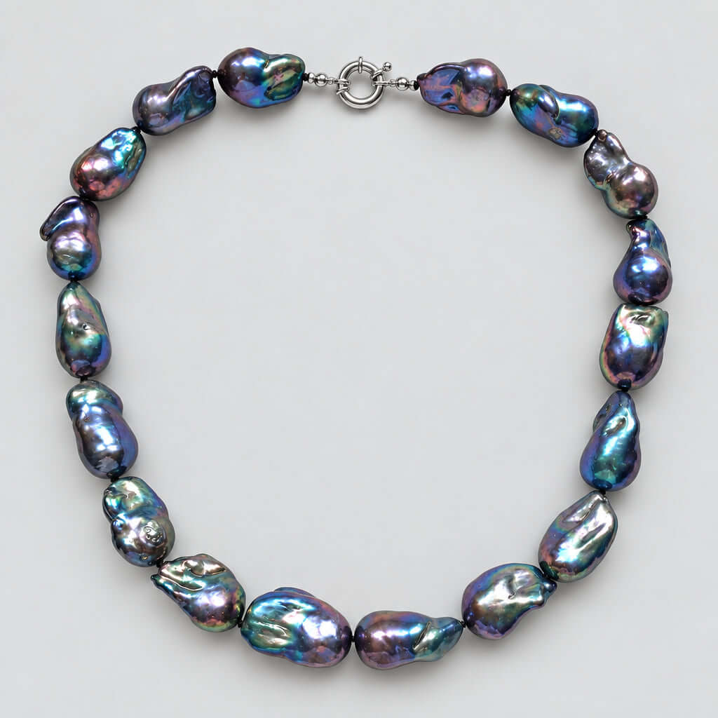 A baroque pearl necklace made of irregular, iridescent beads with a silver clasp, displayed on a plain white background.