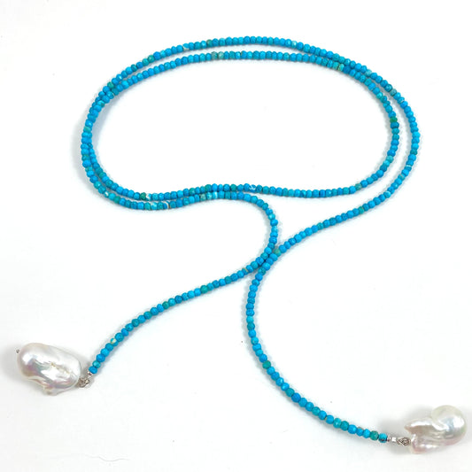 A turquoise blue beaded necklace with two large, irregular white baroque pearls at the ends, displayed on a clean white background.