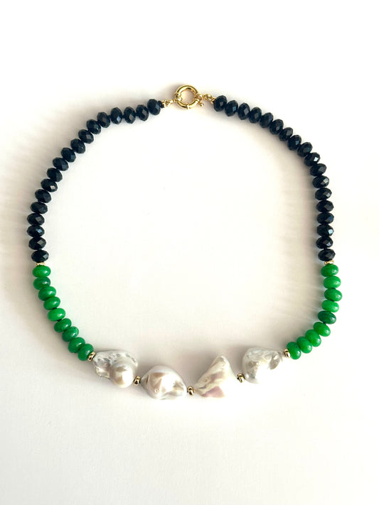 A beaded necklace featuring BLACK TOURMALINE faceted beads on one side, bright green JADE beads on the other, and 4 irregular white baroque pearls in the center, finished with a gold clasp.